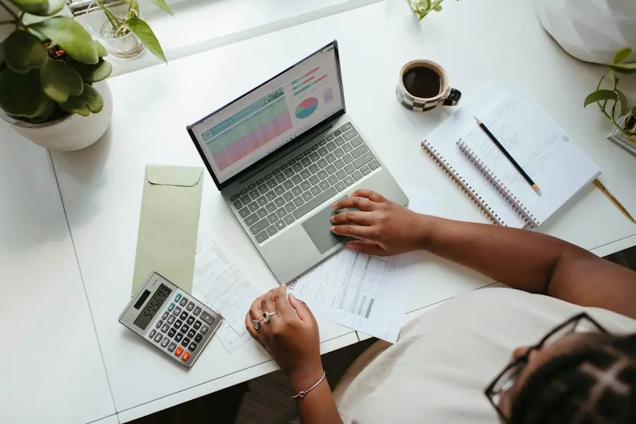 Laptop met grafieken, rekenmachine en notities op een bureau